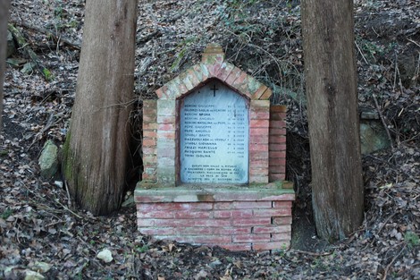 Monumento commemorativo dedicato alle vittime del bombardamento, situato tra alberi nel bosco.
