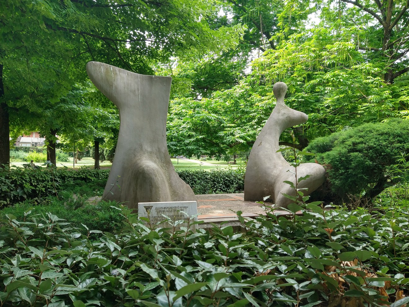 Monumento commemorativo per le vittime dei lager, immerso nel verde, rappresenta il ricordo e la riflessione.