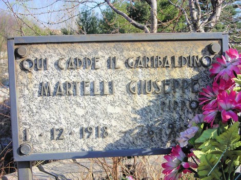 Cippo commemorativo dedicato a Giuseppe Martelli, garibaldino, con fiori in omaggio.