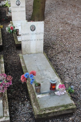 Tombe celebrate in memoriale con fiori, candele e nomi incisi, onorano i caduti per la Libertà.