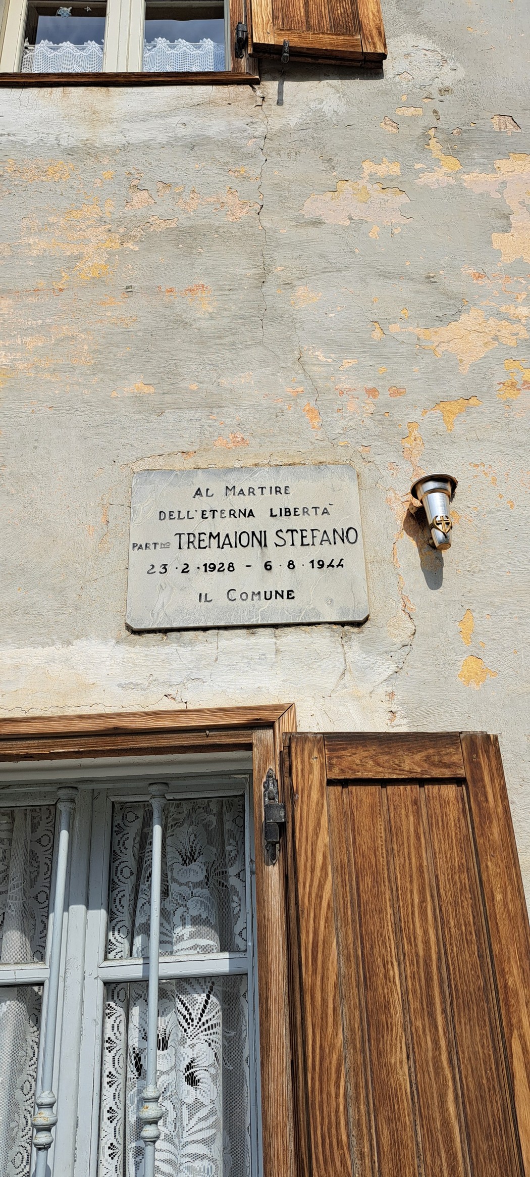 Lapide commemorativa dedicata a Stefano Tremaioni, martire per la libertà, affissa su un edificio.