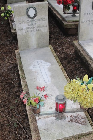 Tombe perpetue dei caduti, decorate con fiori e lanterne, in un contesto serene e commemorativo.