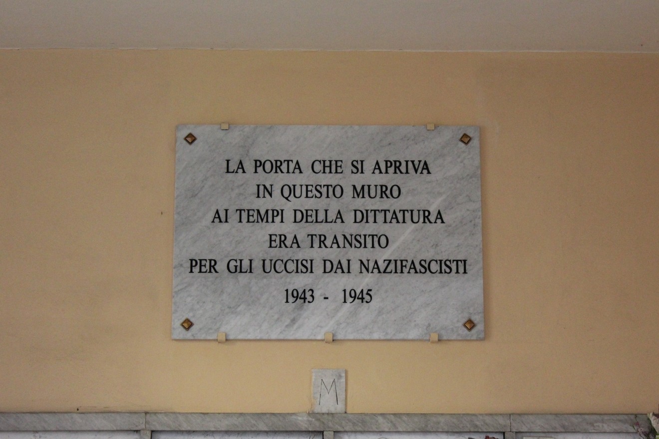 Lapide commemorativa in marmo dedicata agli uccisi dai nazifascisti, con iscrizioni a caratteri neri.