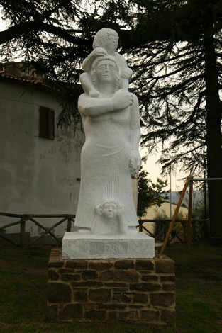 Monumento in pietra dedicato ai caduti, raffigura una madre con un bambino in un gesto di memoriale e pietà.
