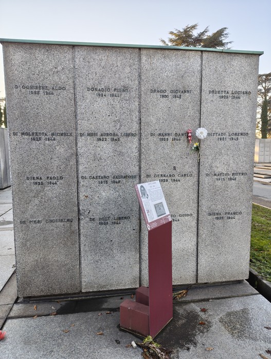 Monumento commemorativo con lastre di pietra incise, dedicato ai caduti della Seconda Guerra Mondiale e di altri eventi storici.
