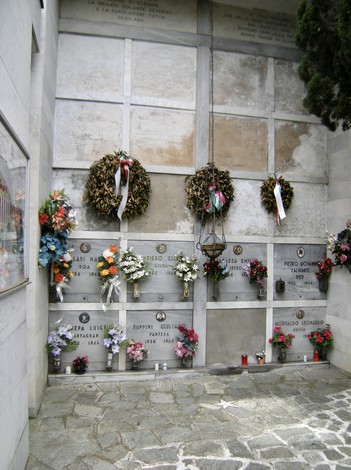 Interno del "Sacrario dei partigiani", con lapidi commemorative e decorazioni floreali in onore dei caduti.