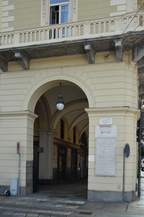 Lapide commemorativa dedicata ai martiri della Camera del Lavoro, situata in un arco architettonico.