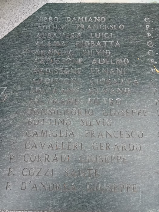 Monumento alla Resistenza, con nomi incisi in memoria dei caduti, simbolo di lotta e libertà.