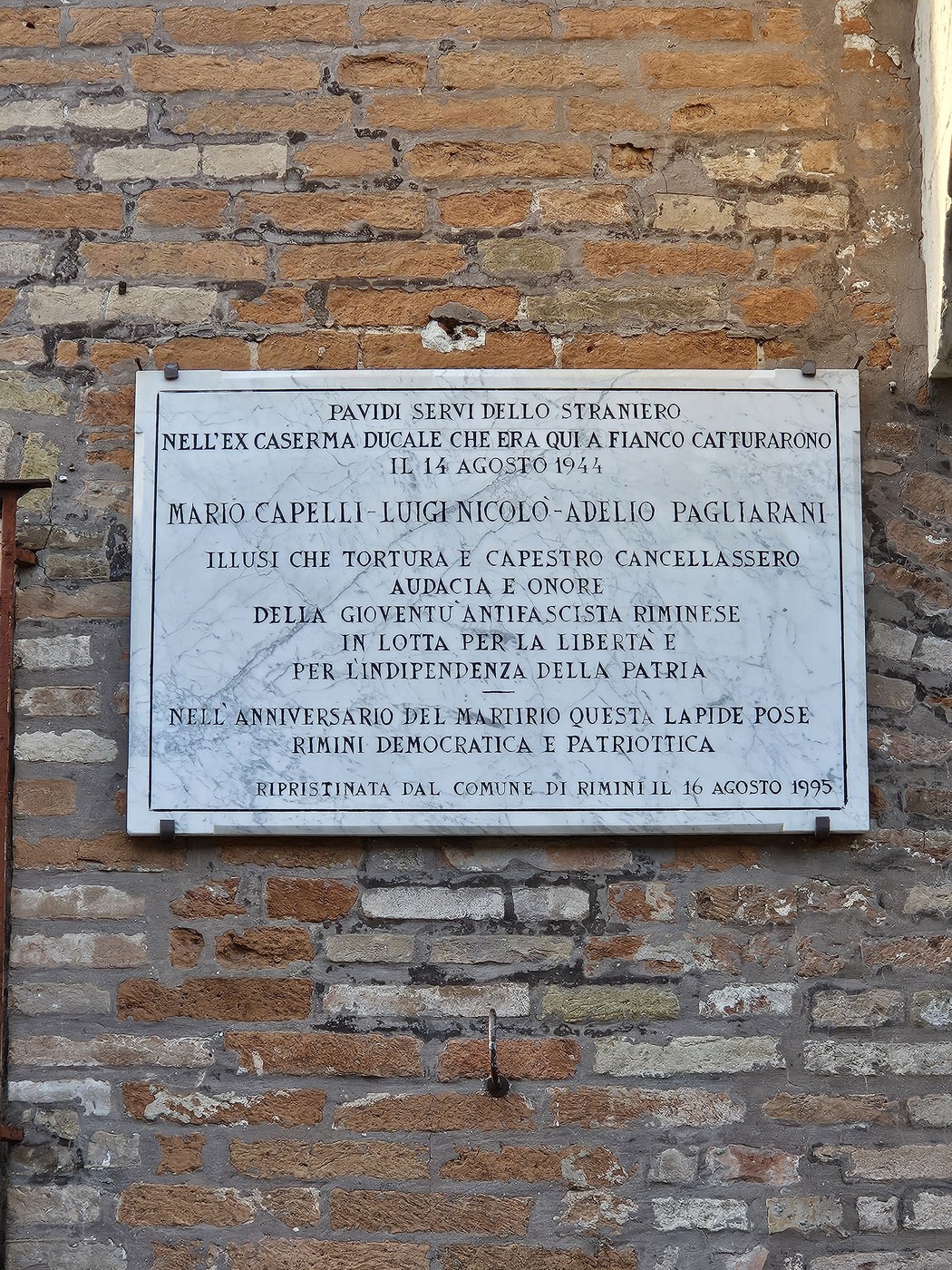 Lapide commemorativa dedicata ai Tre Martiri, con dettagli sulla loro cattura e eroismo.