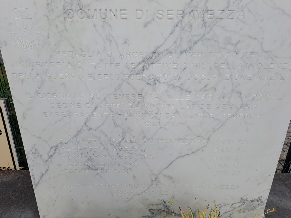 Lastra di marmo bianco con iscrizione incisa, dedicata al Comune di Seravezza, con stemma in alto.