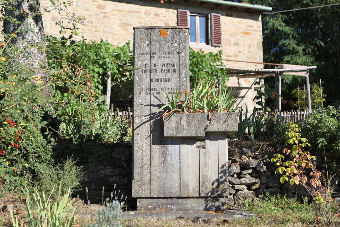 Monumento commemorativo a Pinzani e Pasquini, situato in un contesto naturale e rurale.
