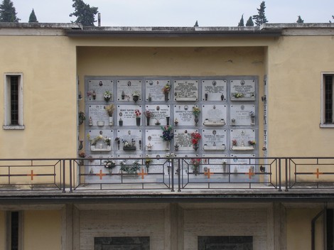 Terrazza dei partigiani: monumento commemorativo con lapidi e fiori in un contesto urbano.