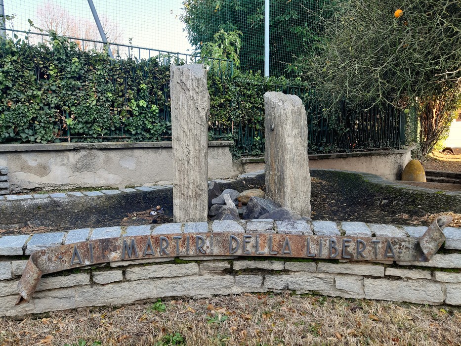 Monumento ai Martiri della Libertà, con stele in pietra e giardino circostante, simbolo di commemorazione.