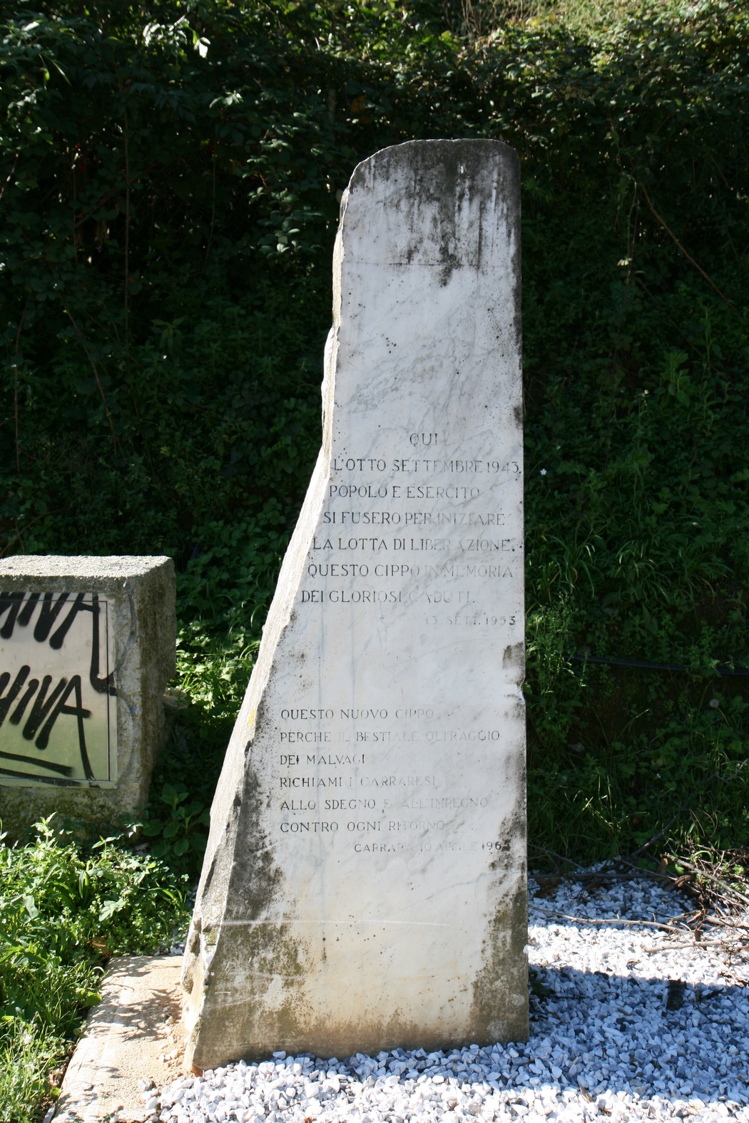 Il Vecchio Cippo della Foce, monumento storico, si erge tra la vegetazione, testimone di eventi passati.