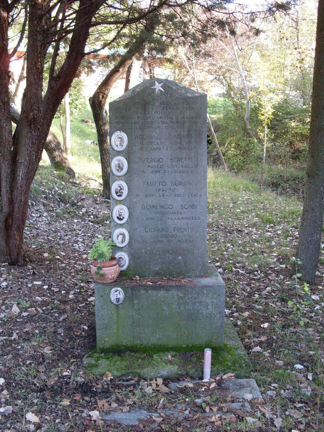 Monumento commemorativo dedicato a Simonini e altri, incastonato nella natura circostante.