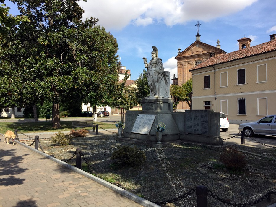 Monumento ai caduti di Robbio, dedicato ai soldati che hanno perso la vita in guerra, circondato da verde.