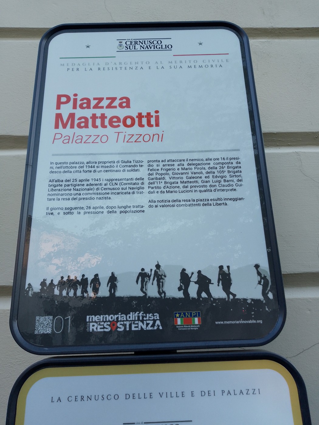 Targa commemorativa che ricorda la resa del presidio tedesco, collocata in un contesto urbano.