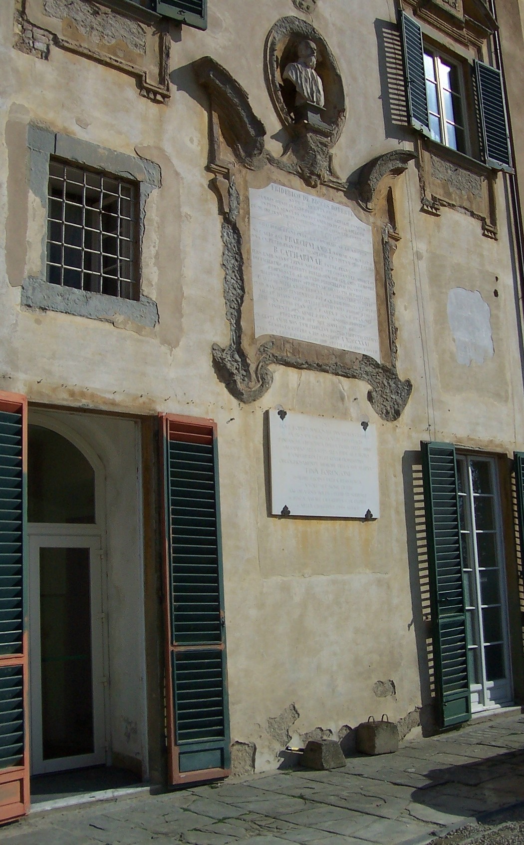 Lapide a Lorenzoni su una parete storica, con dettagli architettonici e finestre colorate.