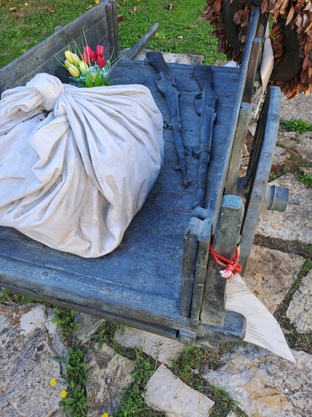 Carretto delle lavandaie con un carico di tessuti e fiori, ambientato in un contesto naturale.