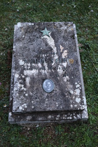 Tomba commemorativa di un partigiano nel Sacrario dei partigiani pratesi, con decorazioni e simboli patriottici.