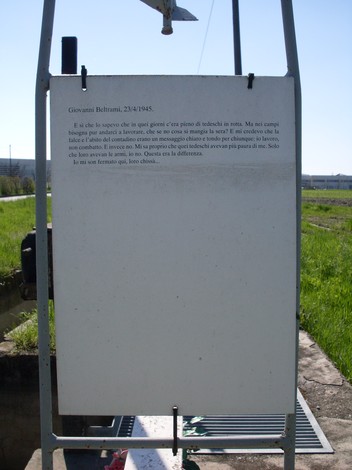 Cippo commemorativo dedicato a Giovanni Beltrami, situato in un'area verde. Ricorda eventi storici e memoriali.