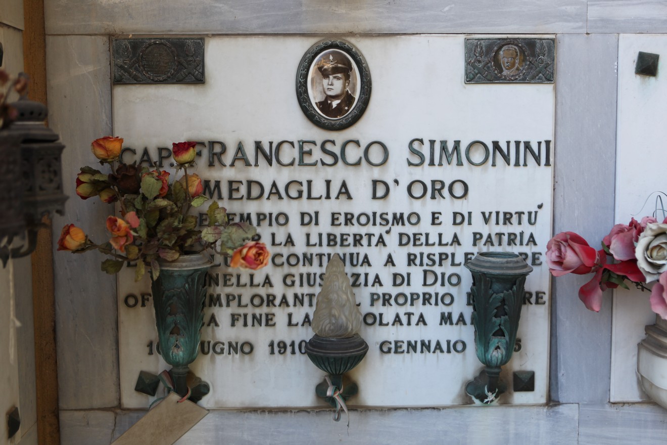 Sepolcro di Francesco Simonini, decorato con fiori e una targa commemorativa dedicata al suo eroismo.