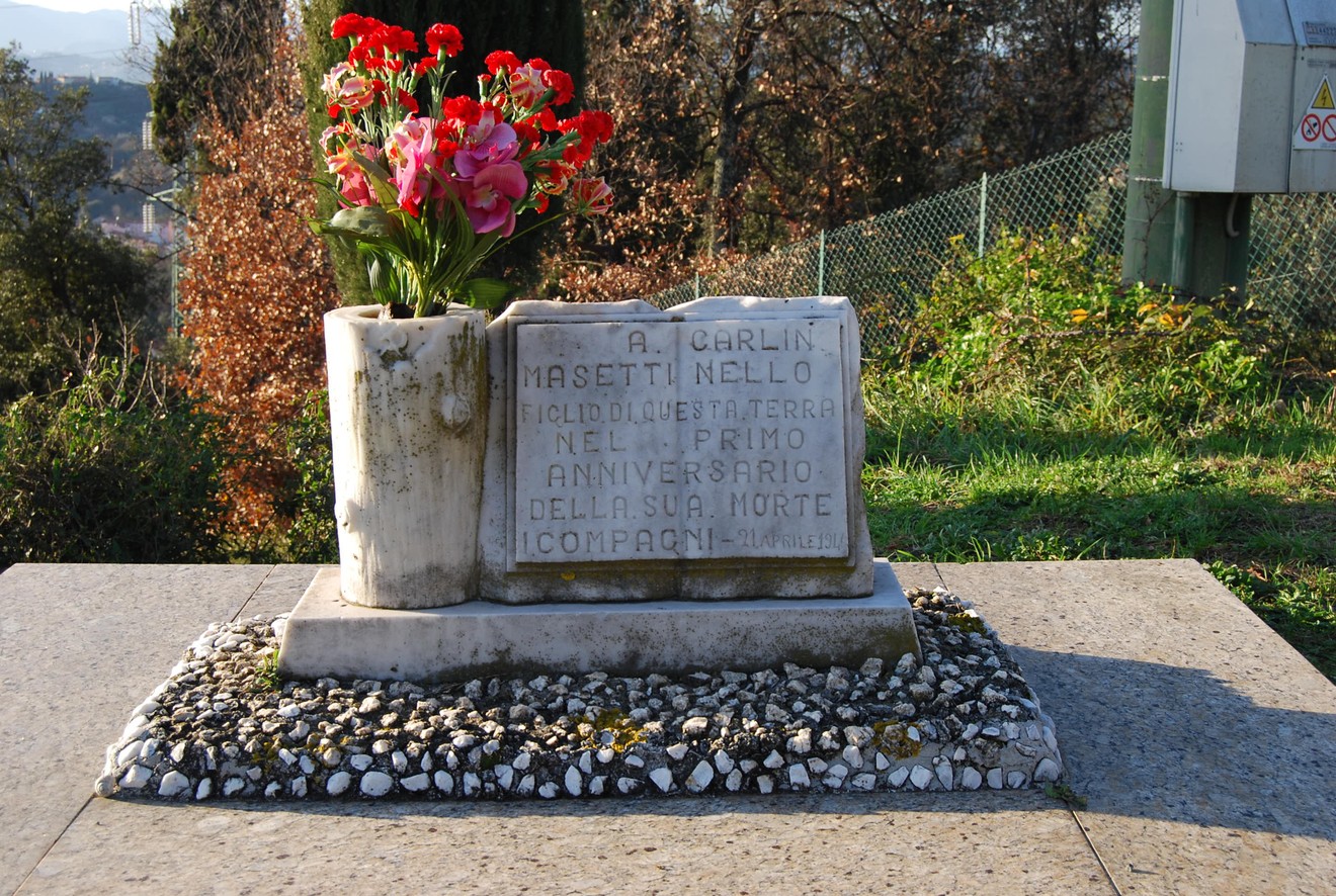 Monumento a Masetti con fiori, commemorativo, situato in un contesto naturale.