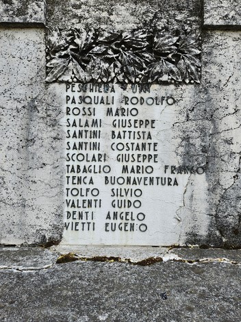 Monumento ai Caduti con iscrizioni commemorative su una parete di pietra.