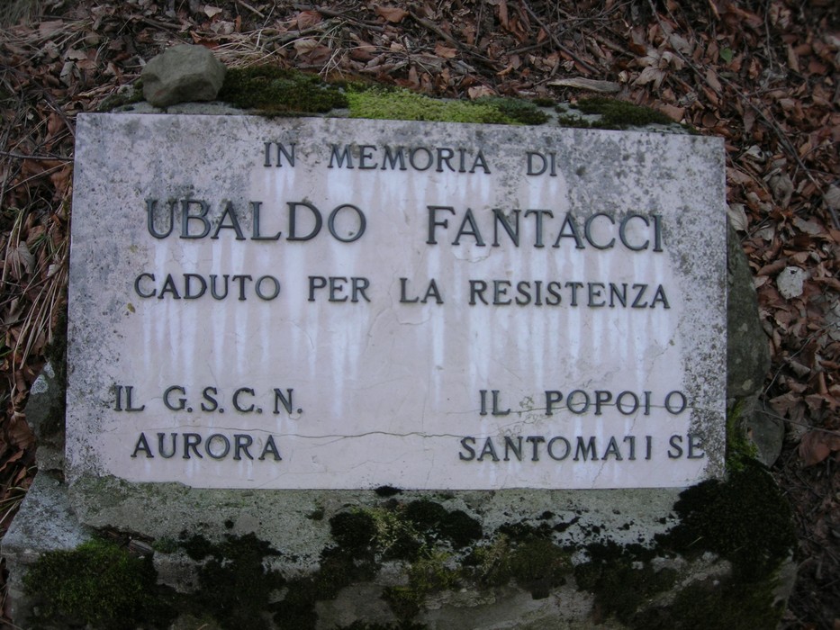 Cippo commemorativo dedicato a Ubaldo Fantacci, caduto per la resistenza, immerso nella natura.