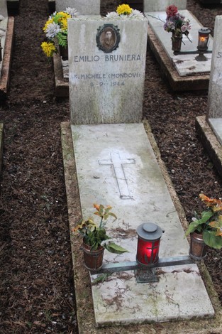 Tombe in memoria dei caduti per la Libertà, con fiori e candele, simbolo di rispetto e ricordo.