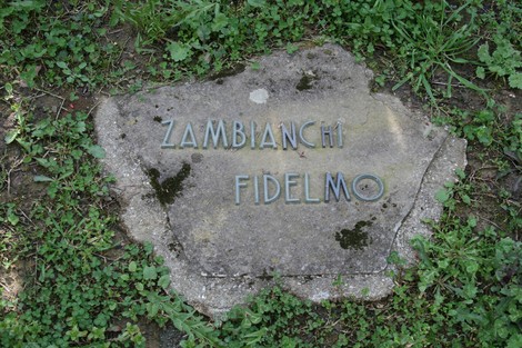 Monumento commemorativo nel cimitero di Stia, dedicato a Fidelmo Zambianchi, immerso nel verde.