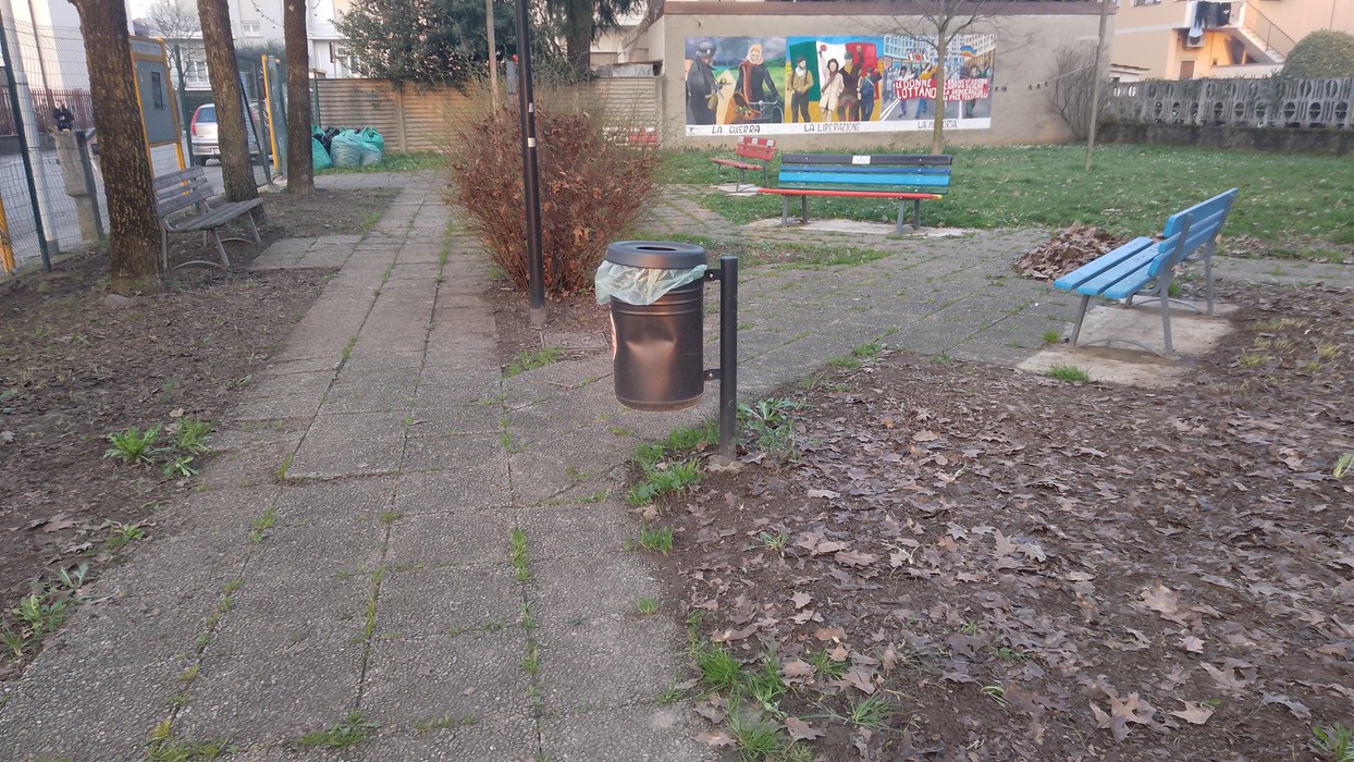 Panorama del parco Donne della Resistenza, con panchine e un cestino in un'area verde.