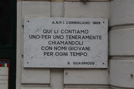 Lapide commemorativa ai partigiani con dedica significativa e riferimento a una citazione di S. Quasimodo.