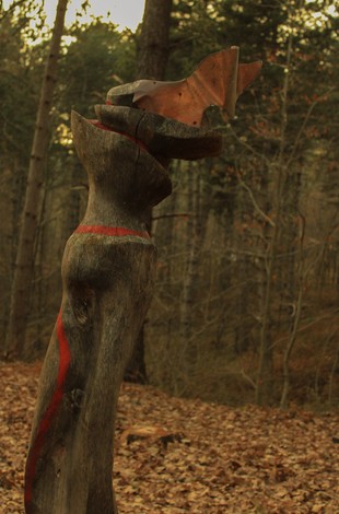 Scultura a Gabarini immersa nel bosco, gioca con forme sinuose e materiali naturali, evocando sensualità e armonia.