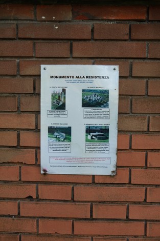 Il Monumento alla Resistenza, un omaggio storico, inserito in un contesto urbano di mattoni.