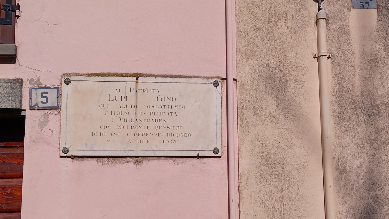 Lapide commemorativa dedicata a Lupo Gino, situata su un edificio storico.