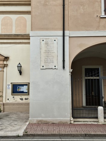 Lapide commemorativa dedicata alla Resistenza, posizionata su un edificio storico.