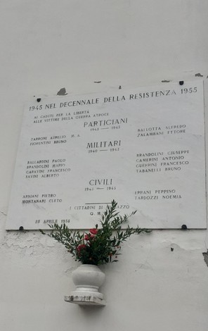 Lapide commemorativa che ricorda i caduti di Fiumazzo durante la Resistenza, con nomi di militari e civili.