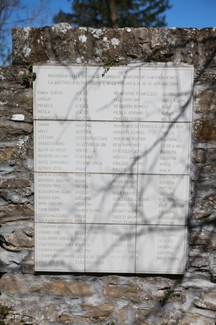 Monumento commemorativo dedicato alla battaglia di Ca' di Malanca, con elenchi di nomi scolpiti.