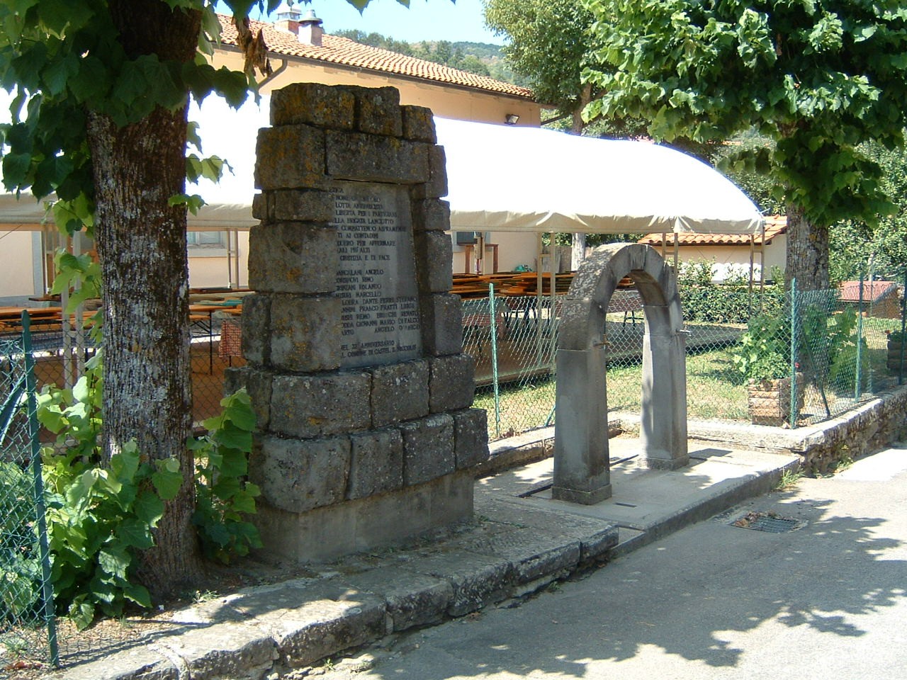 Monumento di Cetica, un memoriale storico situato in un contesto naturale, circondato da alberi.