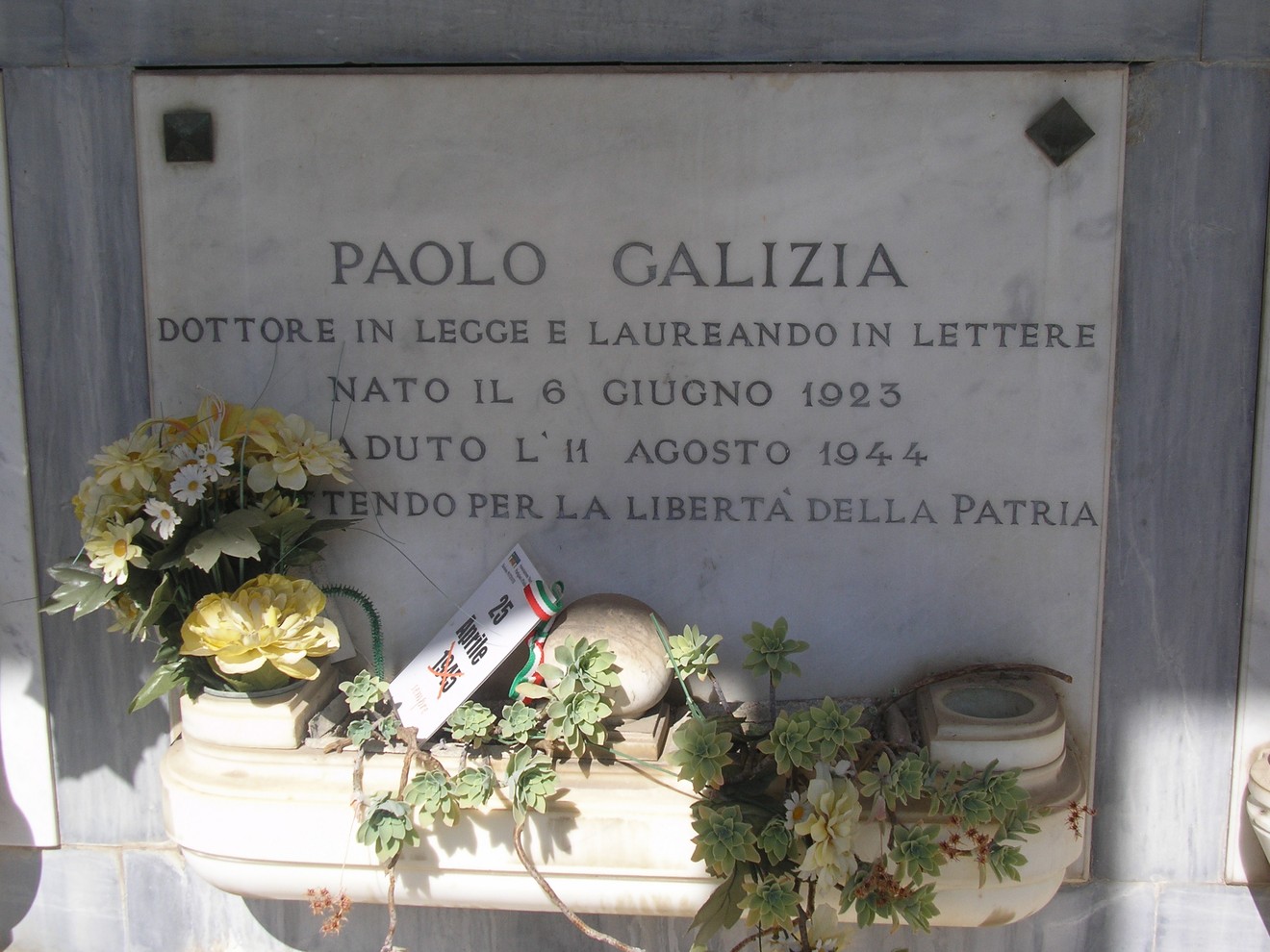 Sepolcro di Paolo Galizia, dedicato a un patriota e medico scomparso nel 1944. Decorato con fiori e tributi.