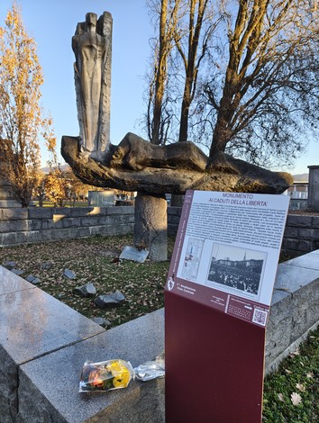 Monumento ai caduti della Liberazione, con statua e pannello informativo, circondato da alberi e un'area verde.