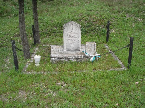 Cippo commemorativo in una zona verde, con una semplice lapide e adornato da fiori. Rappresenta la memoria di Tassi e Magi.