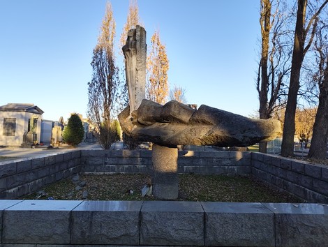 Monumento ai caduti della Liberazione, con una scultura centrale di una mano e un obelisco. Ambiente urbano circondato da alberi.