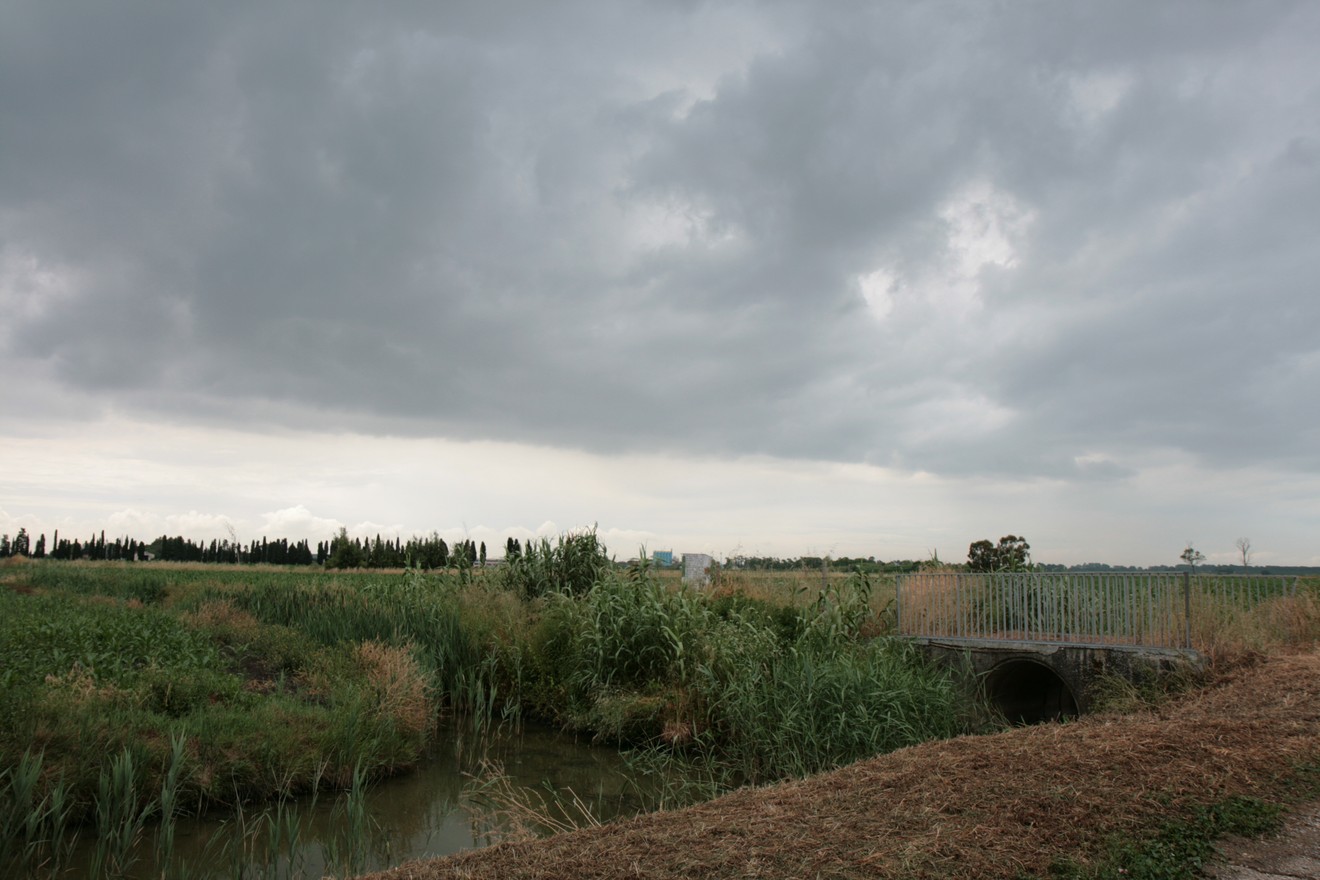 Cippo del Fosso Reale in un paesaggio italiano con nuvole e vegetazione. Un luogo di interesse storico e naturale.