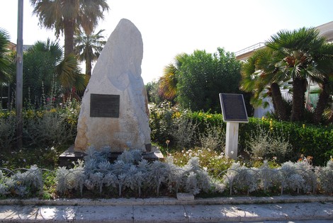Monumento a Campioni, obelisco circondato da vegetazione, simbolo di commemorazione e rispetto.
