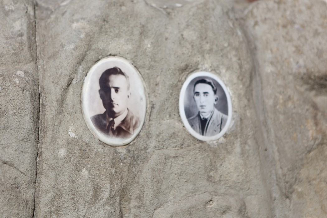 Monumento dedicato a Meglini e ai fucilati di Campo di Marte, con ritratti incastonati nella pietra.