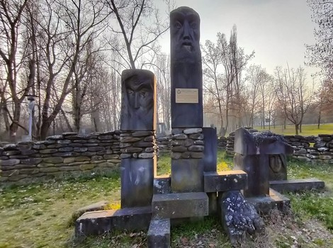 Monumento ai caduti della valle del Panaro, con statue e basamenti in un contesto naturale. Atmosfera serena.