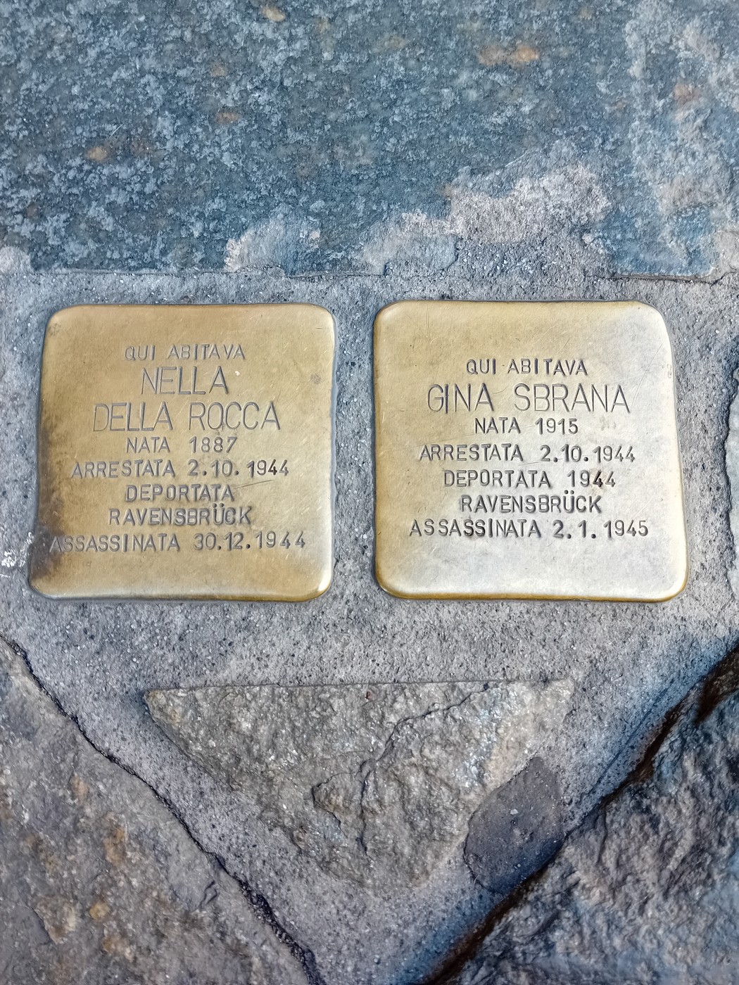 Due pietre d'inciampo in ottone incastonate nel selciato, ciascuna con iscrizione dedicatoria.