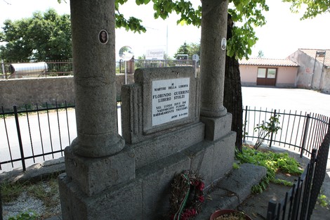 Monumento commemorativo a Guerrini e Stolzi, con dettagli architettonici e vegetazione circostante.